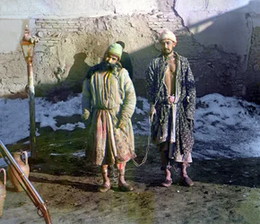 Zwei Gefangene in Ketten und ein Wächter hinter ihnen, Russisches Reich, zwischen 1905 und 1915